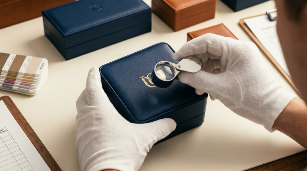 Professional packaging sample kit with material swatches, color cards, and finished jewelry box samples on a desk